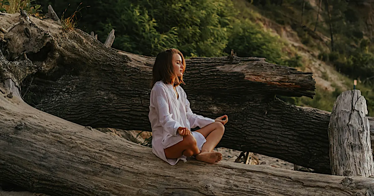 A serene scene of a person meditating outdoors, surrounded by nature, evoking a sense of peace and balance.